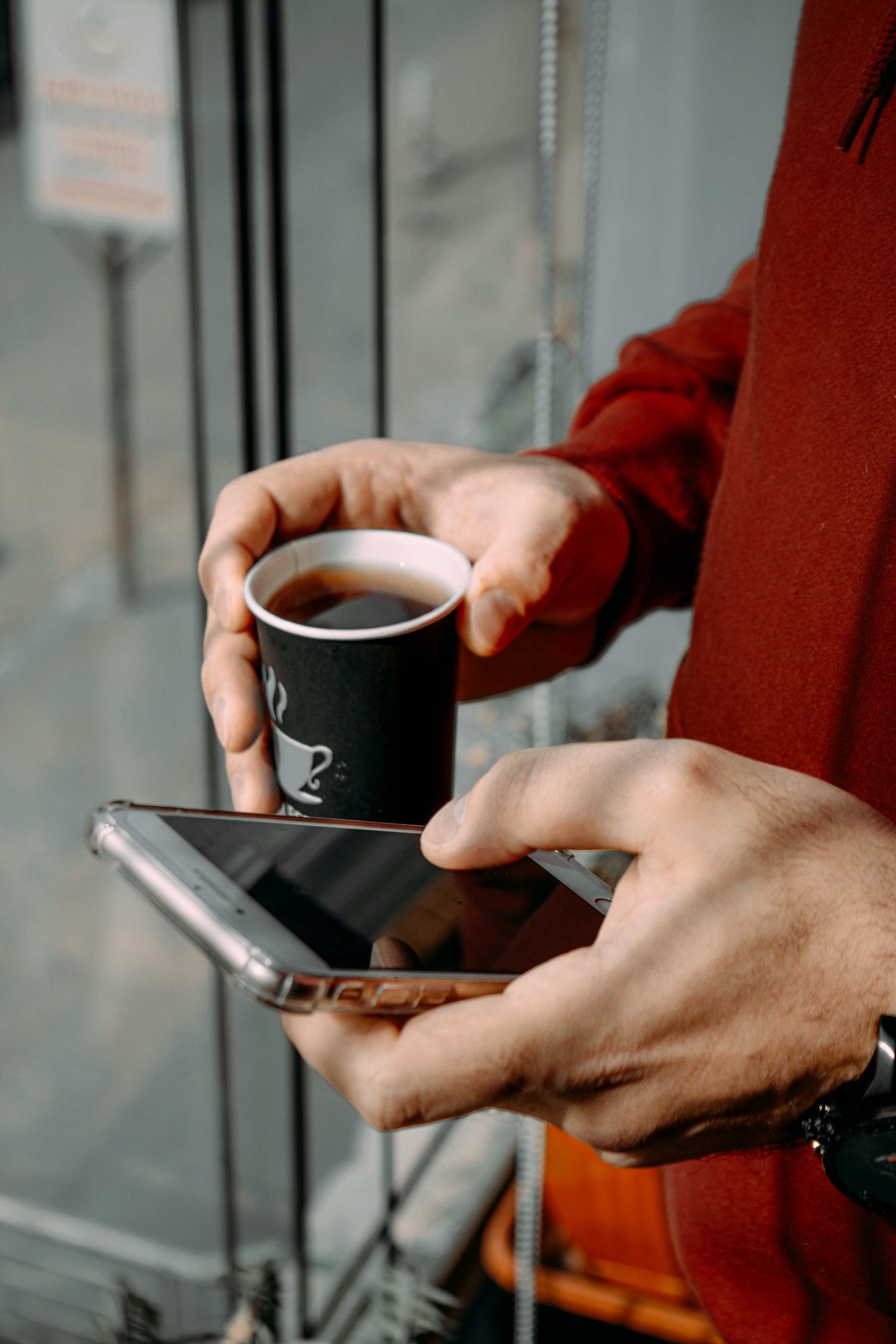 Landlord checking applicant requests on a smartphone over coffee